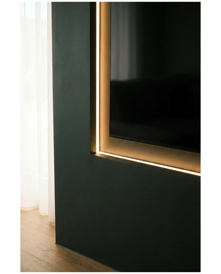 Close detail of a media wall edge, showing the finish and shadow line around the television recess